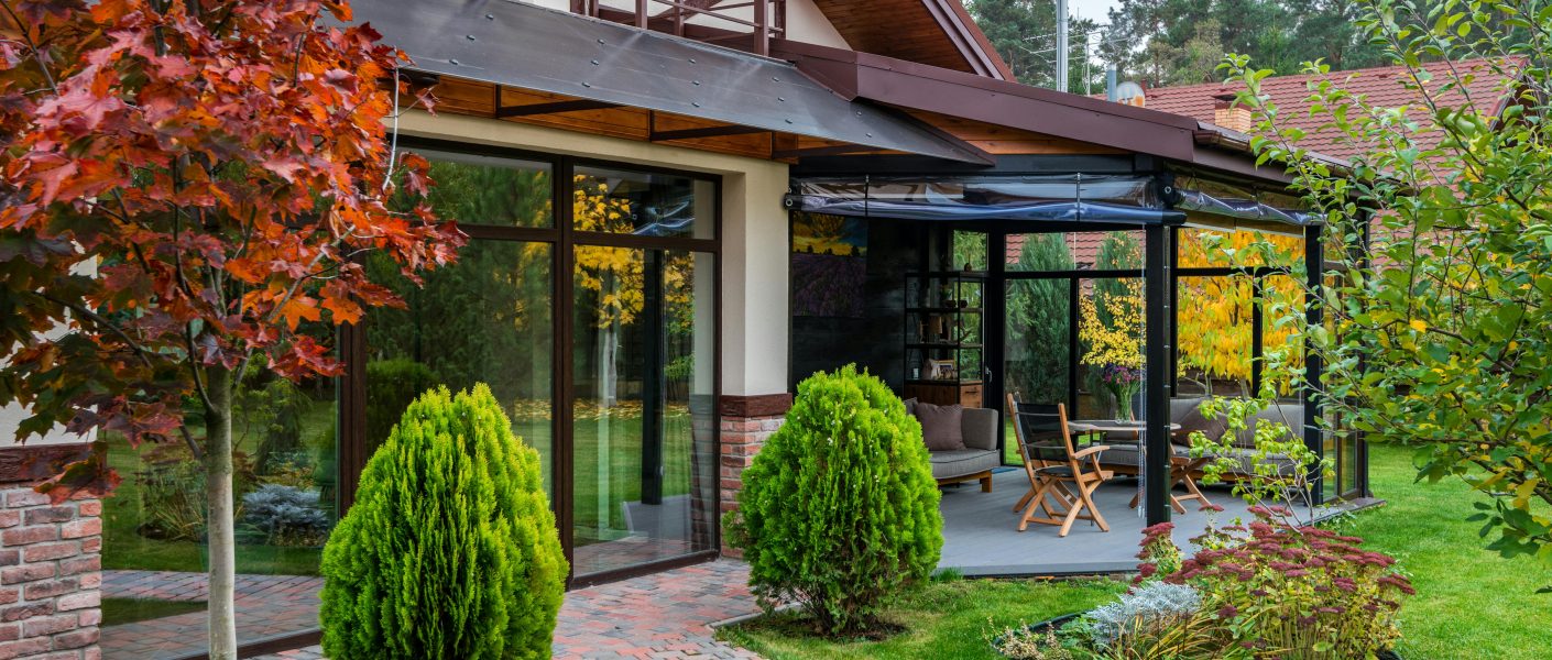 Grădina unei vile de oraș amenajată modern, cu plante decorative, mobilier exterior și atmosferă relaxantă.
