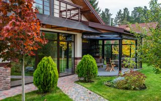 Grădina unei vile de oraș amenajată modern, cu plante decorative, mobilier exterior și atmosferă relaxantă.